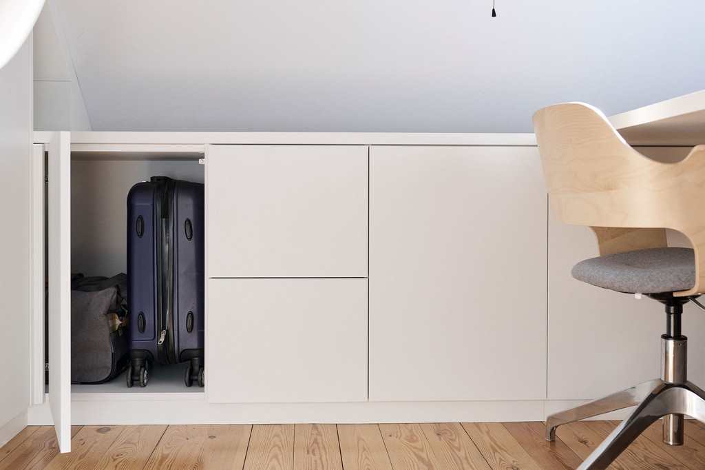 Espace de rangement fermé dans meuble sur mesure sous pente