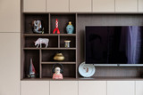 Mur TV sur mesure avec niches ouvertes en finition bois pour exposer des objets décoratifs, combiné à des rangements fermés dans un intérieur moderne, réalisé par Camber