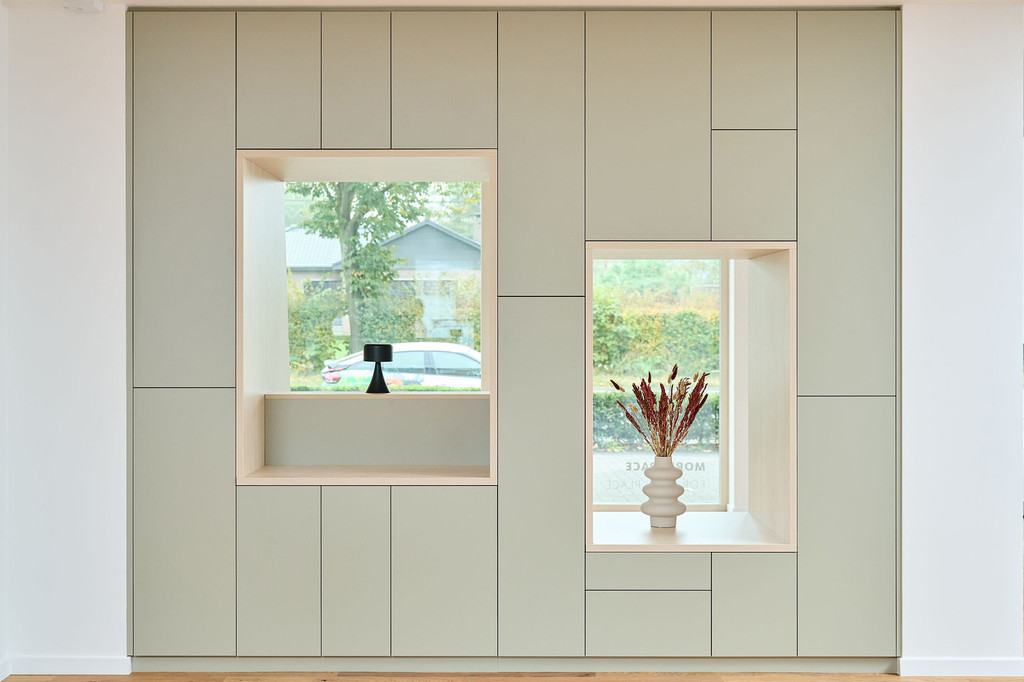 Op maat gemaakte wandkast met grote nisvensters en stijlvolle decoratieve vazen, ontworpen voor een moderne woonkamer.