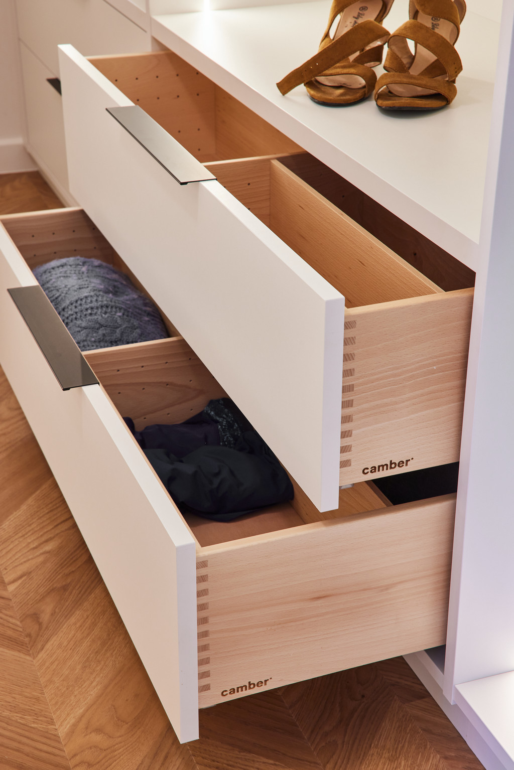 Tiroirs en bois dans un dressing sur mesure avec rangements pour vêtements pliés