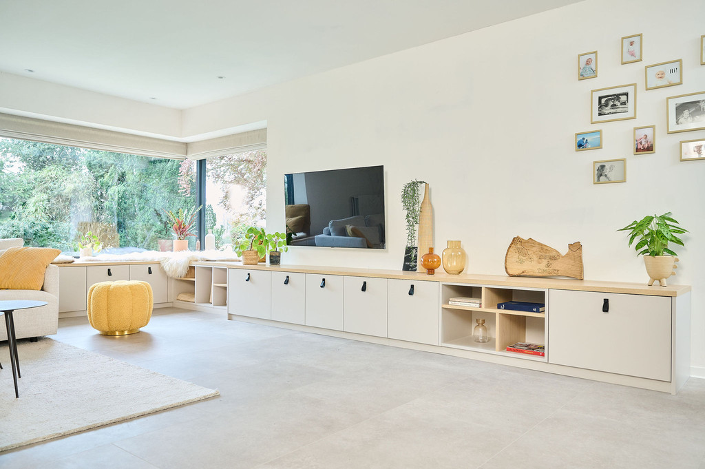 Meuble bas de salon sur mesure avec rangement ouvert et fermé, accompagné de décorations modernes et plantes.