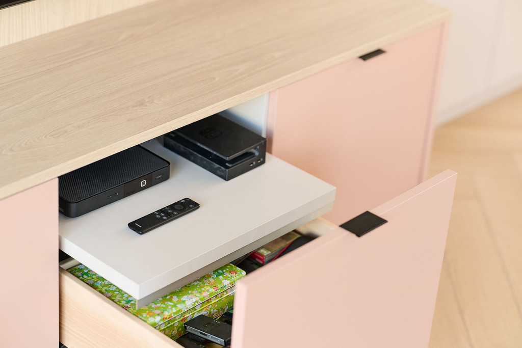 Tablette coulissante dans un meuble TV sur mesure pour ranger les appareils multimédia et les accessoires électroniques