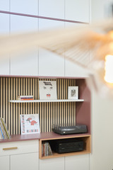 Détail d’un meuble sur mesure avec panneau à lattes niche ouverte pour vinyles et platine intégrée