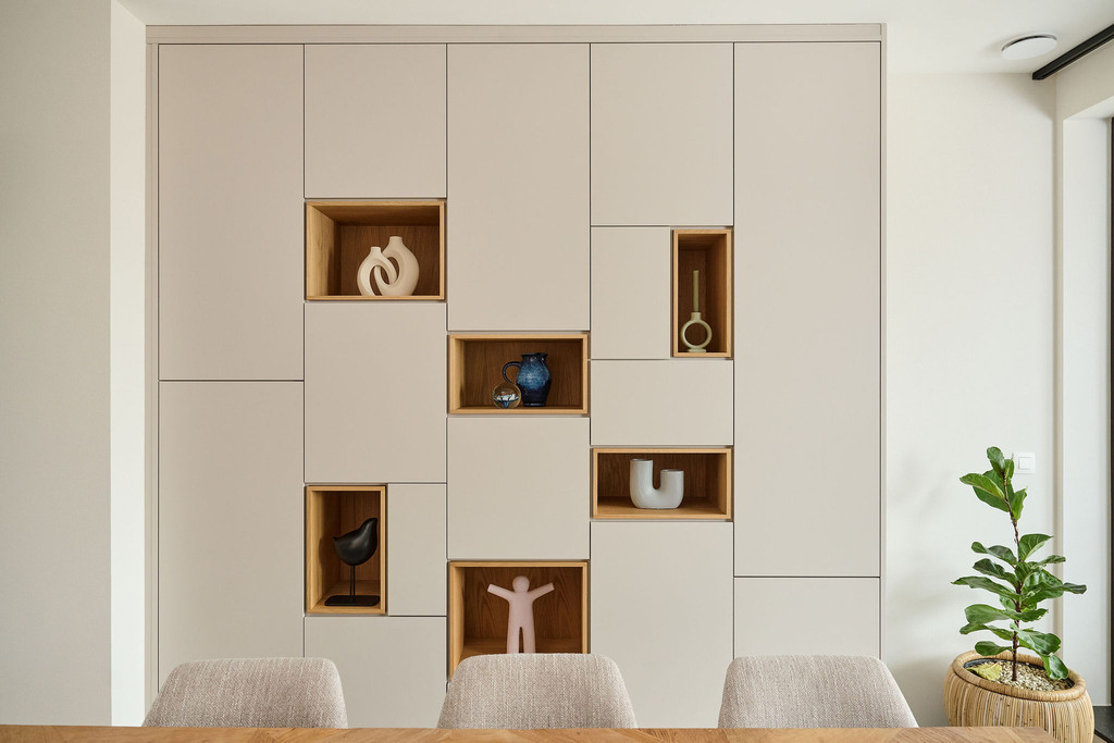 Placard sur mesure avec niches ouvertes en finition bois et accents chaleureux, permettant de mettre en valeur des objets décoratifs dans un intérieur moderne, réalisé par Camber
