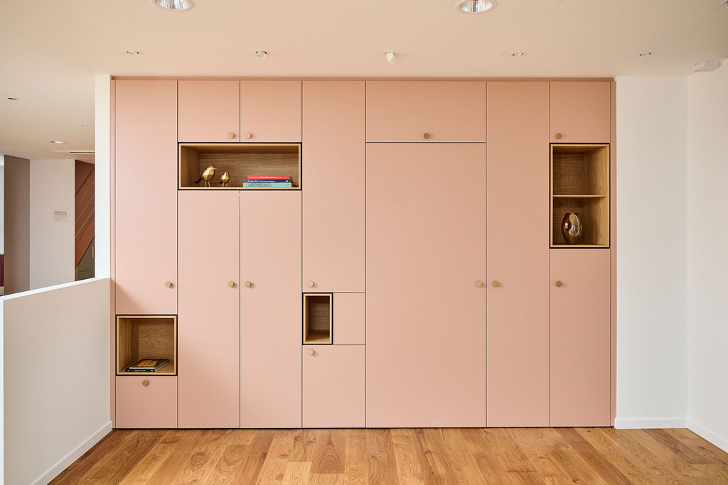 Mur d’armoires sur mesure couleur saumon avec niche intégrée