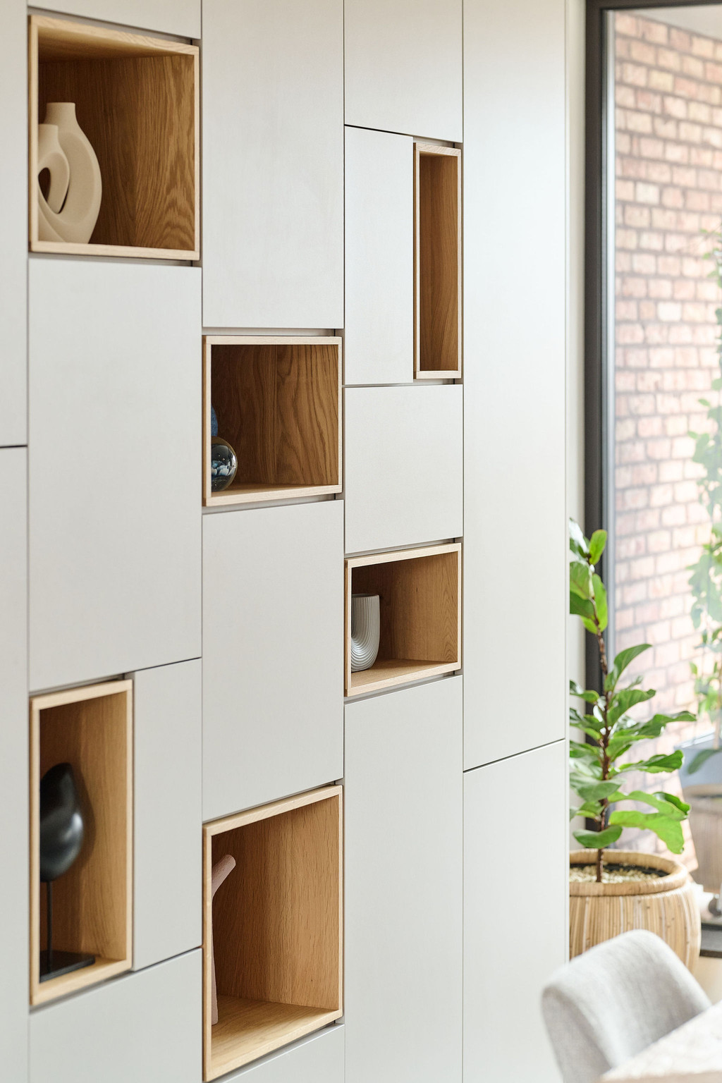 Placard sur mesure avec niches ouvertes en finition bois intégrées dans un design épuré, combinant rangement fermé et mise en valeur d’objets décoratifs, réalisé par Camber