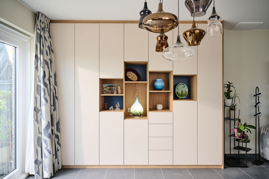 Wandkast op maat met witte fronten en open houten nissen in verschillende formaten voor decoratie en opbergruimte