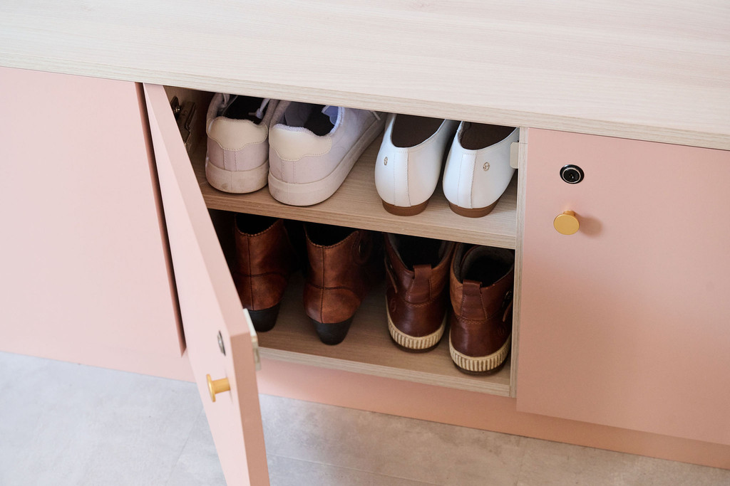 Armoire à chaussures rose ouverte avec deux rangées de chaussures bien rangées