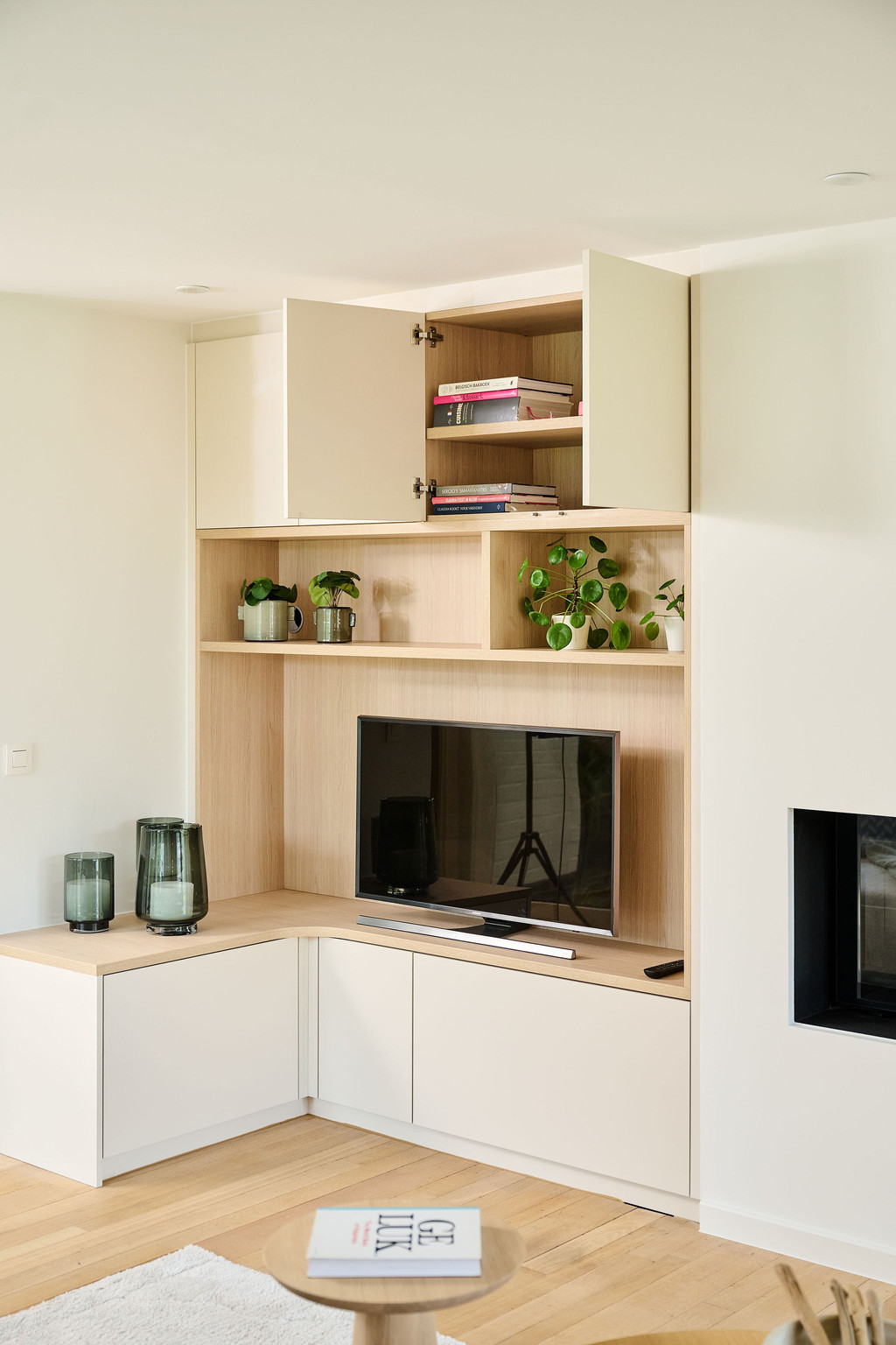Hoek-tv-meubel op maat met open vakken met decoratie en geopende bovenkasten