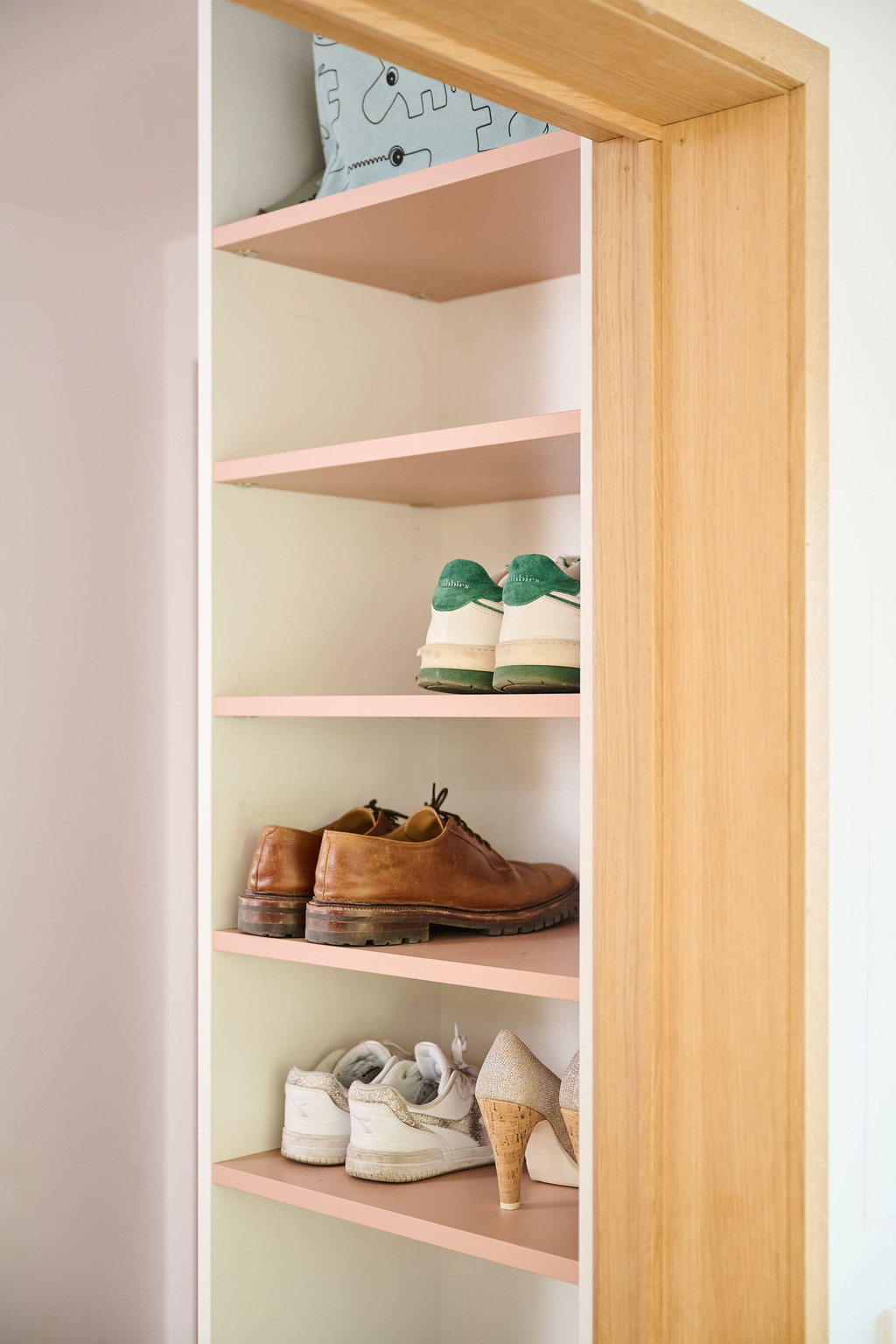 Détail d’une vestiaire Camber sur mesure avec rangement à chaussures ouvert et étagères, permettant un rangement ordonné des chaussures, avec des finitions claires et des accents en bois chaleureux
