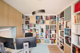 Thuisbureau met bureau op maat en wandvullende boekenkasten met open vakken voor een grote collectie boeken en strips