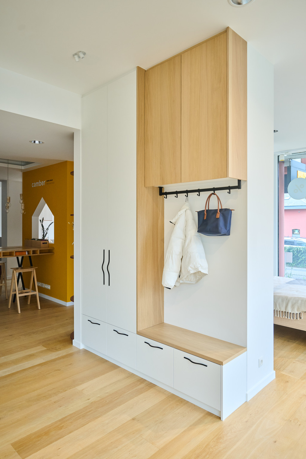 Vestiaire sur mesure avec banc en bois, porte-manteaux et rangements dans un hall d’entrée