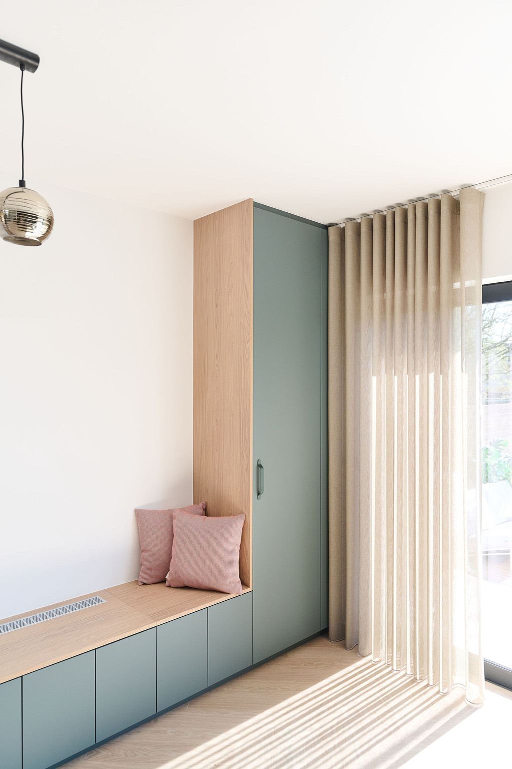 Maatkast met houten kast en geïntegreerde zitbank, ideaal voor een praktische en stijlvolle zitplek in een lichte ruimte