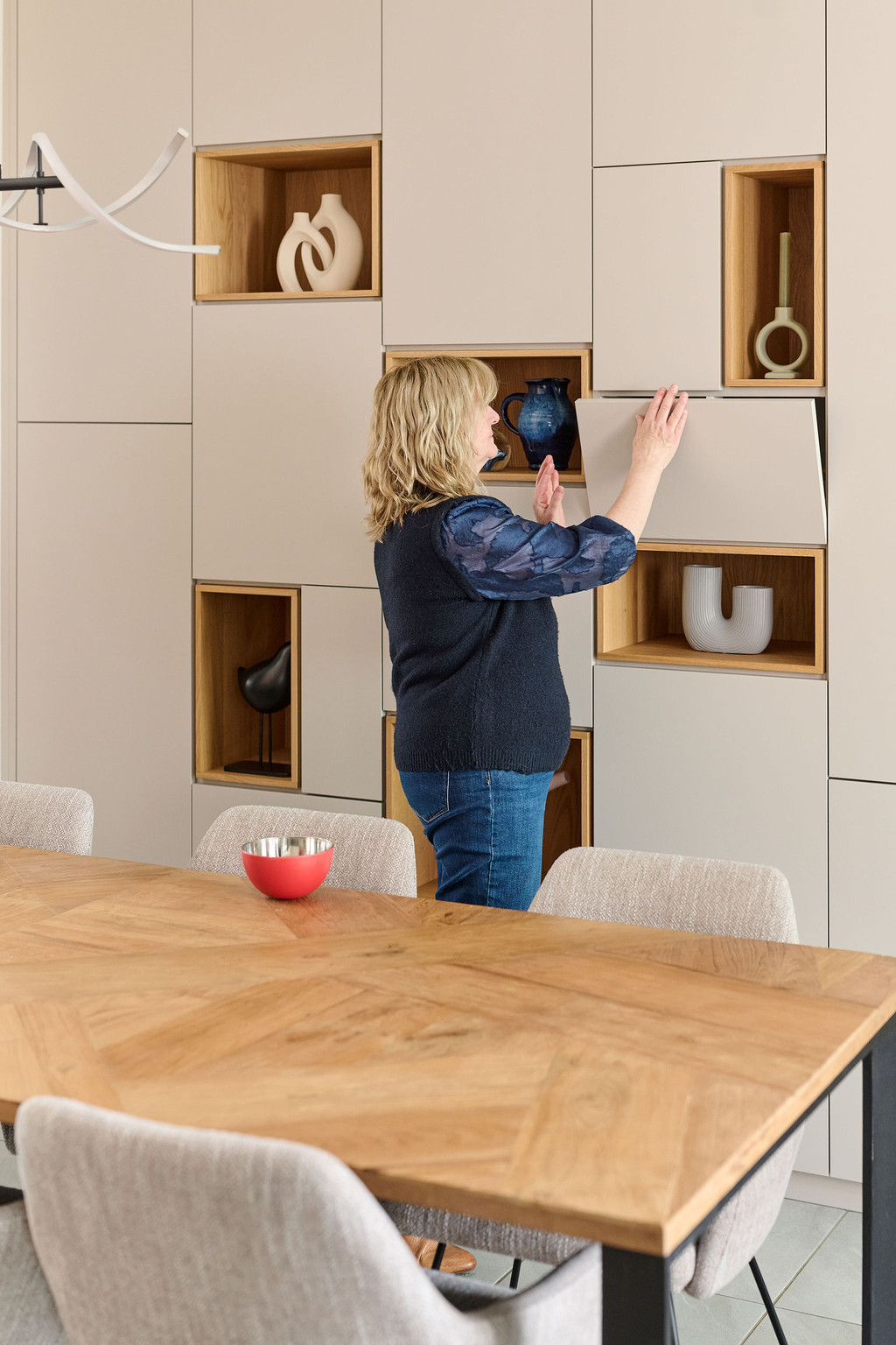 Placard sur mesure avec niches ouvertes en finition bois et porte relevable, utilisé dans une salle à manger pour un rangement pratique et discret, réalisé par Camber