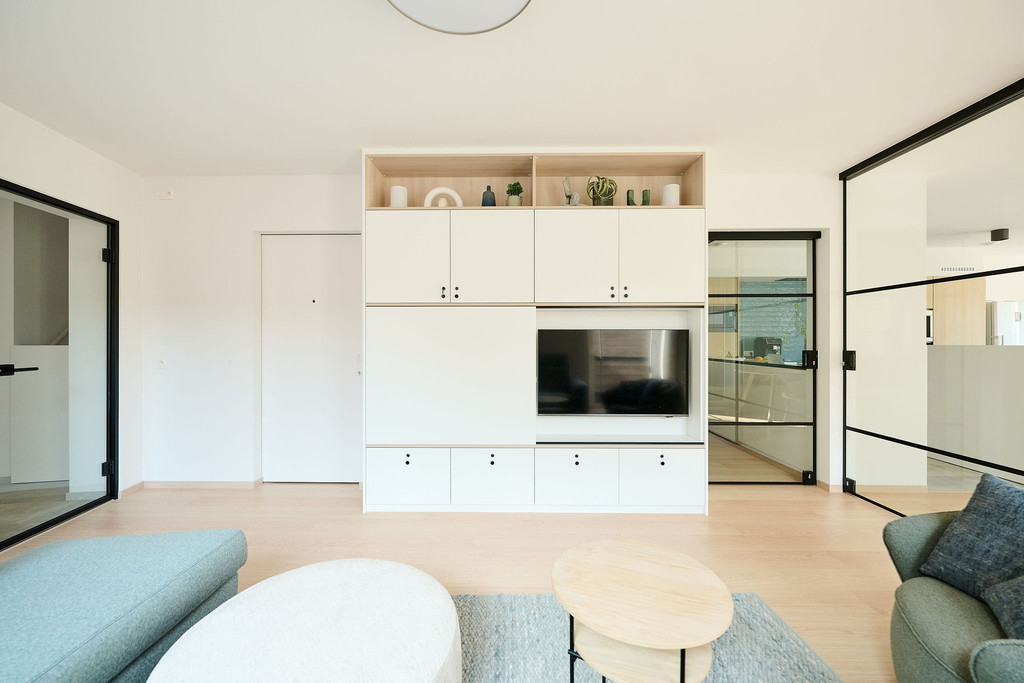 Meuble mural blanc sur mesure avec niche TV et étagères décoratives dans un salon lumineux