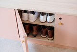 Armoire à chaussures rose ouverte avec deux rangées de chaussures bien rangées