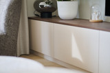 Meuble bas avec plateau en bois et portes fermées dans un salon lumineux