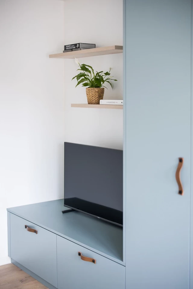 Bureau sur mesure avec étagères et télévision intégrée, design épuré et moderne pour chambre d’enfant.