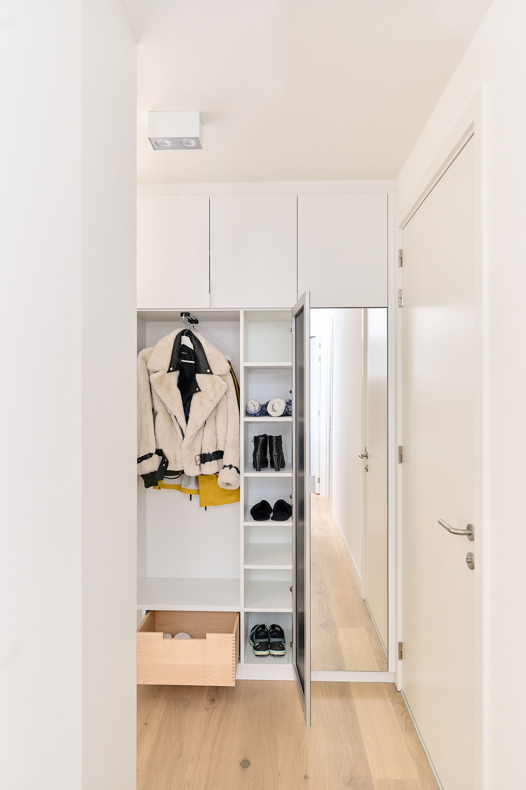 Vestiaire sur mesure avec espace pour vestes et chaussures chez Ilse et Dominique à la côte