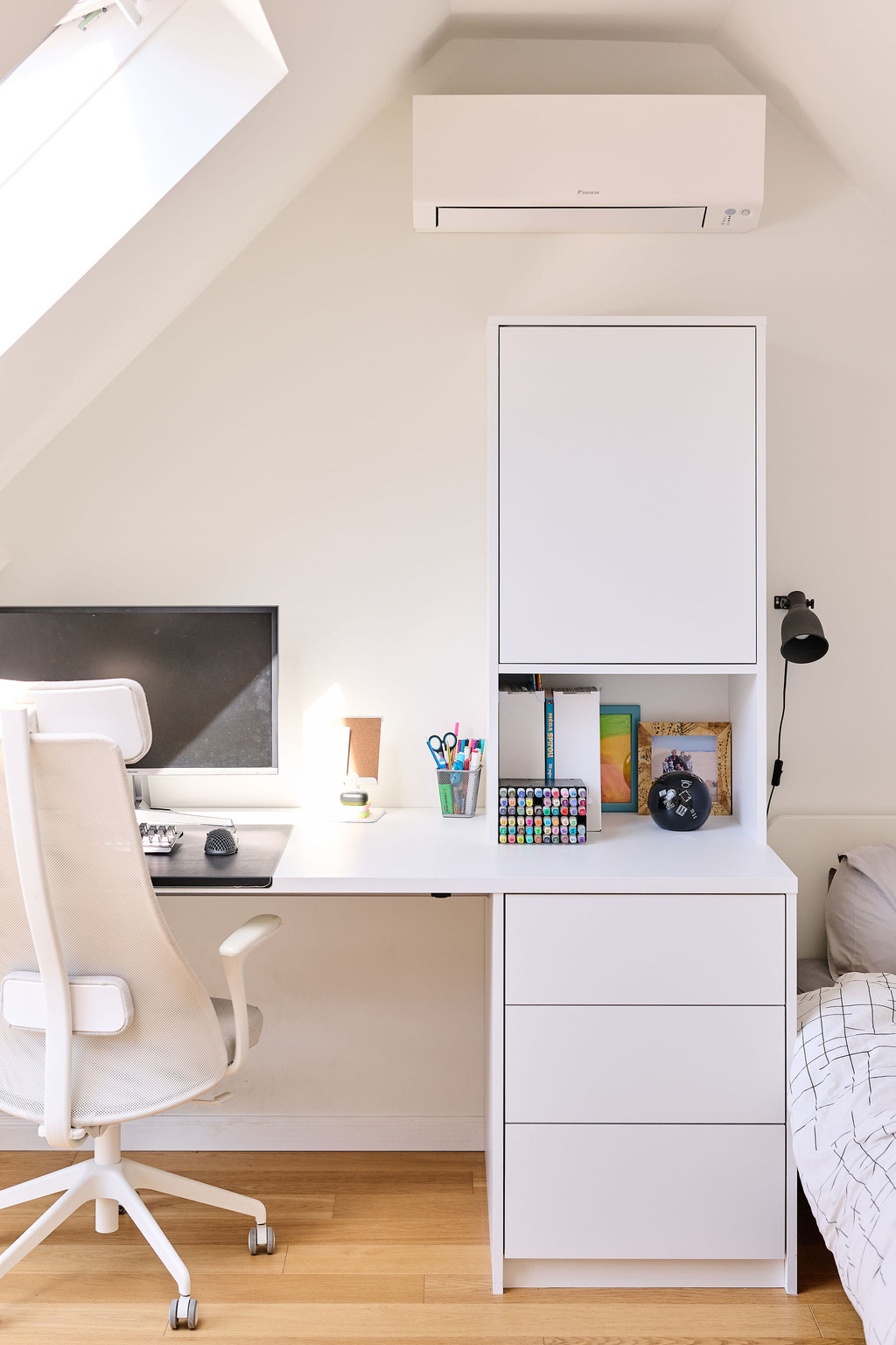 Bureau blanc sur mesure avec placard et rangements sous pente dans une chambre d’enfant
