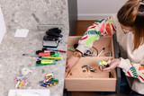Personne triant des fournitures et piles dans un tiroir de rangement sur mesure.