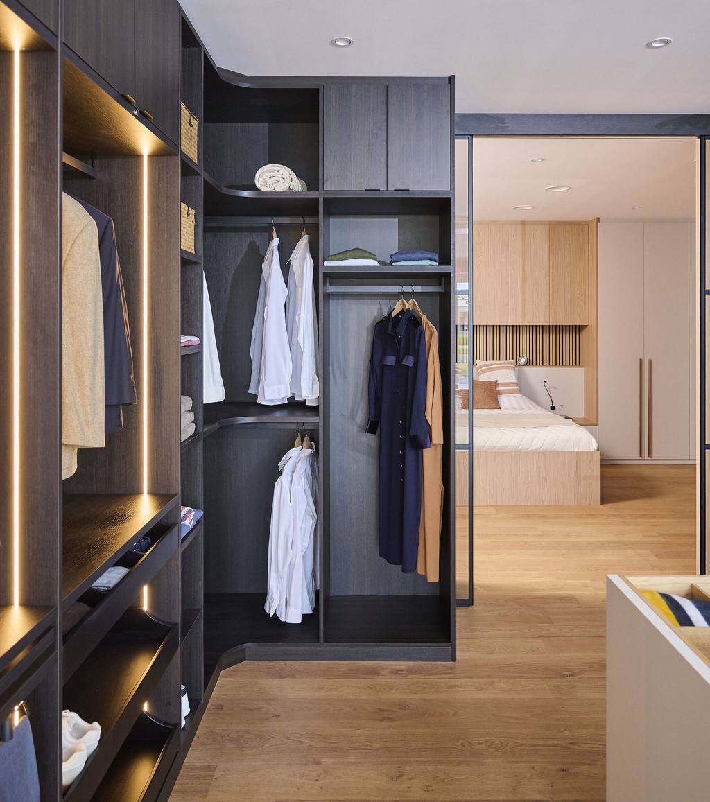 Dressing d’angle sur mesure avec penderie, niches ouvertes et éclairage LED intégré en showroom