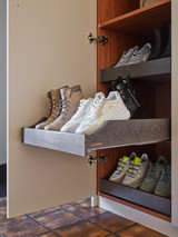 Armoire vestiaire en bois avec tiroir coulissant rempli de baskets et bottines