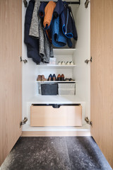 Open maatkast in vestiaire met jassen, schoenen en lades voor accessoires